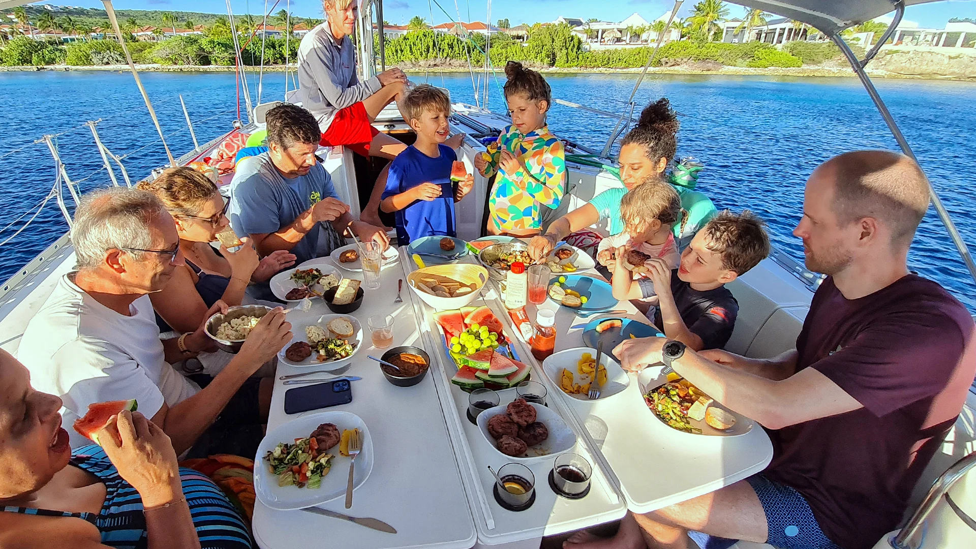 A family sharing dinner at a table on deck