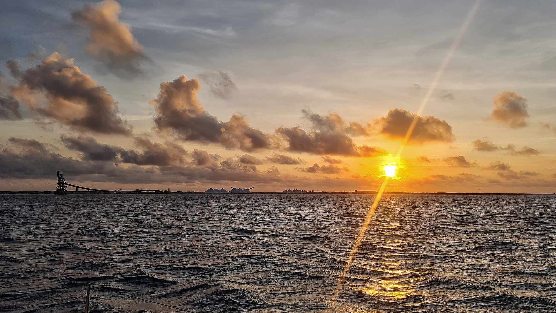 Sunrise rays breaking over the horizon at sea