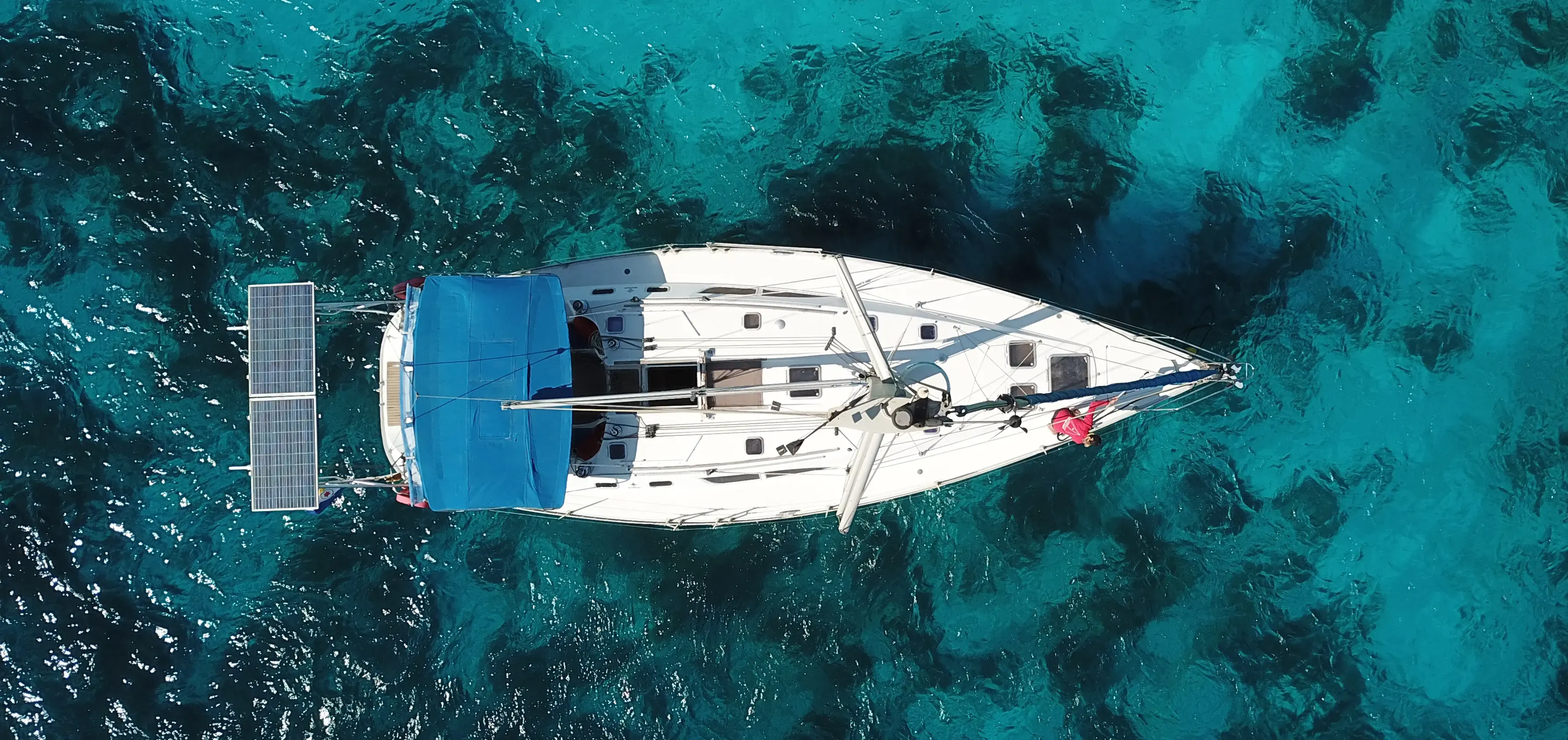 Top-down drone view of Phoenix over deep turquoise reef water
